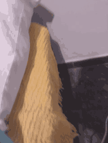 a yellow blanket is sitting on a bed next to a white pillow