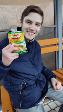 a man is holding a bag of reeva noodles