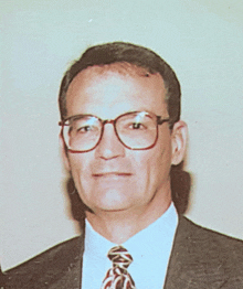 a man in a suit and tie with glasses