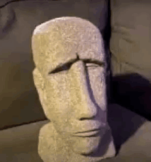 a statue of a head is sitting on a couch .