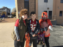 a boy wearing a jersey with the number 37 on it poses with two other kids