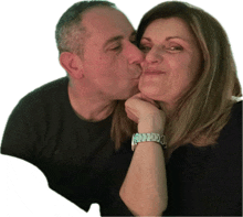 a man kisses a woman on the cheek and she has a watch on her wrist