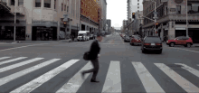 a person crossing a street in front of a building that has a sign on it that says ' no parking '