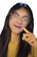 a woman with long hair and glasses is pointing her finger at her face