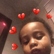 a young girl is taking a picture of herself with broken hearts around her head .