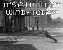 a black and white photo of a man doing push ups with the words `` it 's a little bit windy today ''