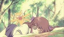 a girl is laying on the ground with a cat behind her in a forest .