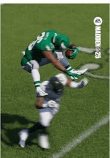 a football player in a green uniform is jumping in the air to catch a ball while another player tries to tackle him .