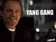 a man with a beard is smiling with the words yang gang written on the screen behind him .