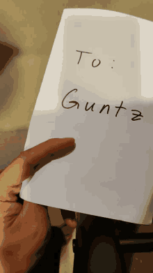 a person is holding a piece of paper that says to gunta