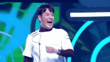 a man in a white shirt is making a funny face in front of a green and blue background