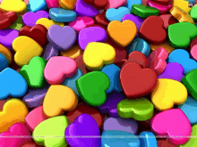 a bunch of colorful hearts are stacked on top of each other on a table