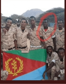 a group of soldiers posing for a picture with a flag in front of them