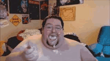 a fat man with glasses and a beard is giving a thumbs up .