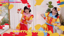 two girls in colorful outfits are dancing in front of a sign that says ' a ' on it