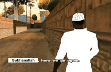 a man in a white hat is walking down a sidewalk next to a brick wall .