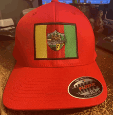 a red flexfit hat with a patch on it