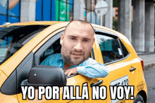 a man sitting in a taxi with yo por alla no voy written on the side