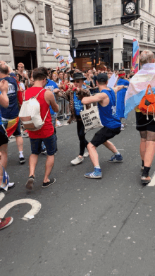 a man in a blue tank top is holding a bag that says " if not you then who " on it