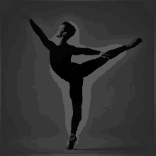 a black and white photo of a male ballet dancer standing on one leg