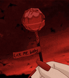 a red lollipop with a sign that says lick me baby on it