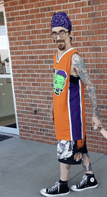 a man wearing an orange and purple jersey with a frankenstein sticker on it