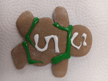 a gingerbread man with green and white frosting and the word uno on it