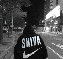 a person wearing a black nike sweatshirt with the word shiva on it