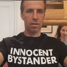 a man wearing an innocent bystander shirt takes a selfie