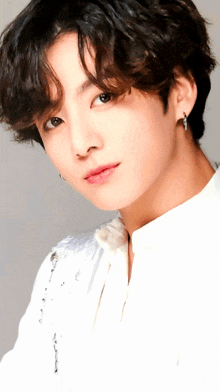 a close up of a young man wearing a white shirt