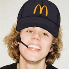 a man wearing a mcdonald 's hat and a headset smiles