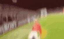 a blurry picture of a soccer player kicking a ball on a field .