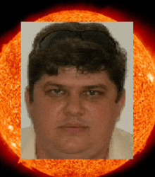 a man 's face is surrounded by a large orange sun