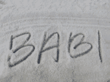 the word babi is written in the snow on a white surface