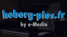 a laptop computer is sitting on a table next to a mouse and the words heberg-plus.fr by e-media .