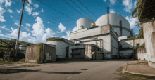 a nuclear power plant with a blue sky and clouds in the background