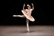 a young ballerina is dancing on a stage .