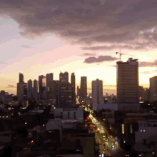 an aerial view of a city skyline at sunset with a few buildings that say ' allianz ' on them