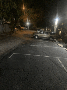 a silver suv is parked in a dark parking lot