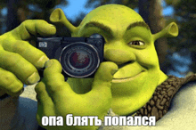 shrek is taking a picture with a camera with a caption in russian