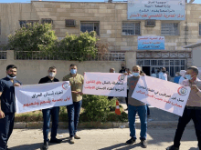 a group of people holding signs in front of a building