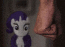 a person is holding a stuffed animal in front of a stuffed pony .