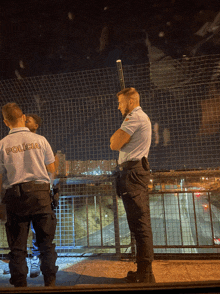 a man in a policia uniform stands next to a woman