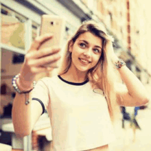 a young woman is taking a selfie with her phone on a city street .