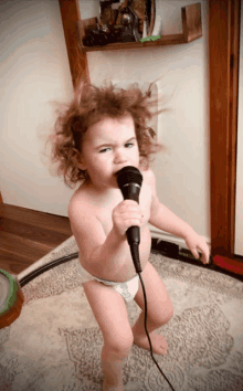 a little girl singing into a microphone with her hair blowing in the wind