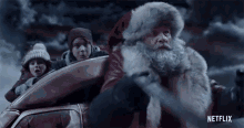 a netflix ad shows a man dressed as santa claus driving a car with two children