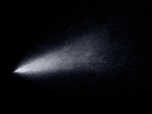 a spray of water on a black background in the dark .