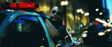 the joker is driving a police car in the dark knight rises .