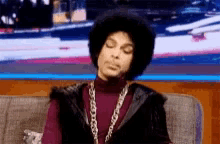 prince is sitting on a couch with closed eyes