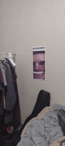 a poster of a smiling man hangs on a wall in a bedroom